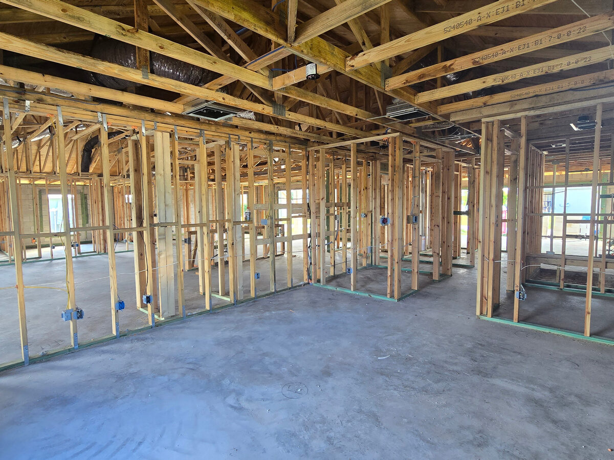 Electrical boxes and plumbing rough-in visible through framing