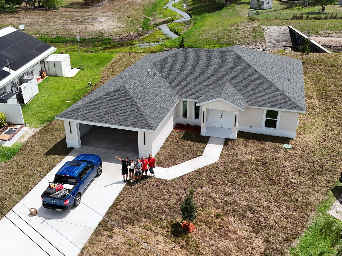 Happy homeowners celebrating in front of their new MEF Home on move-in day