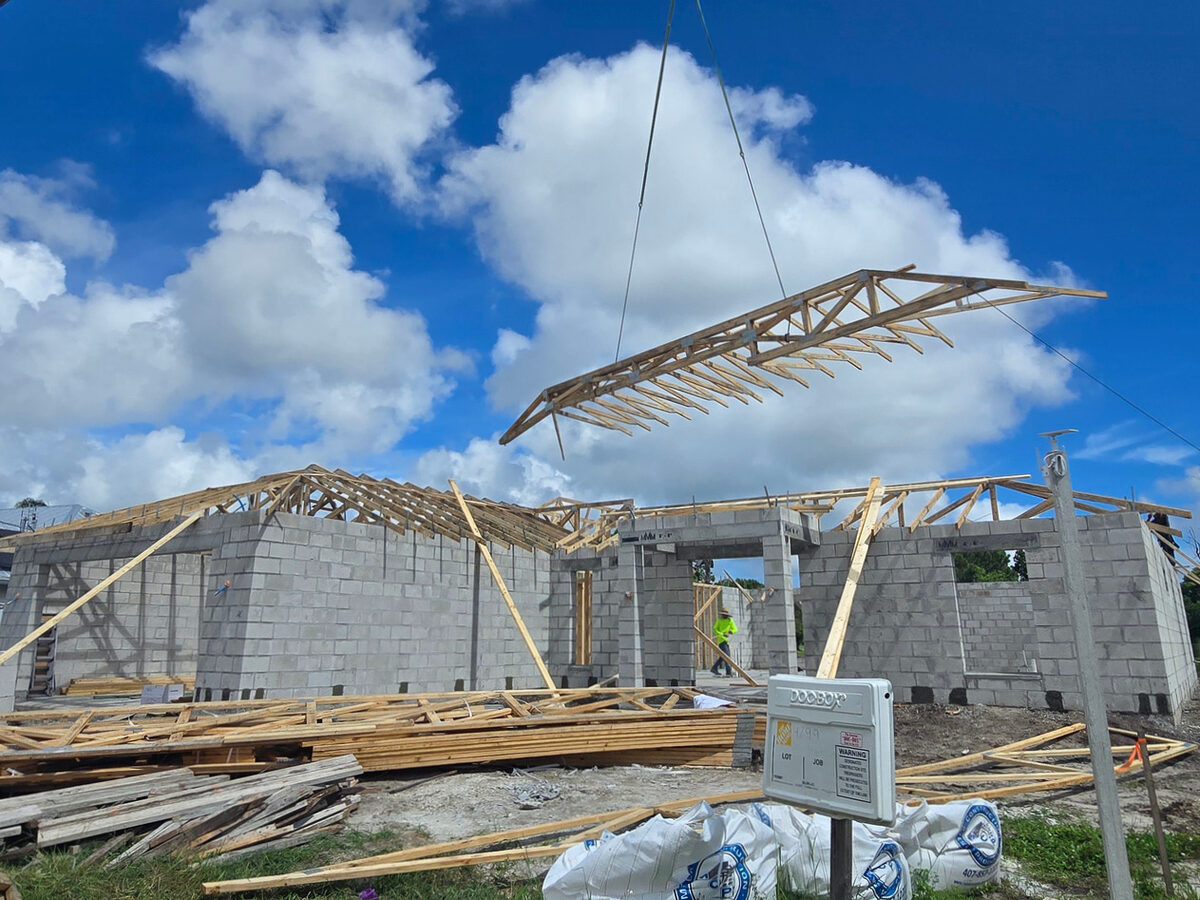 Truss being lifted and installed by crane