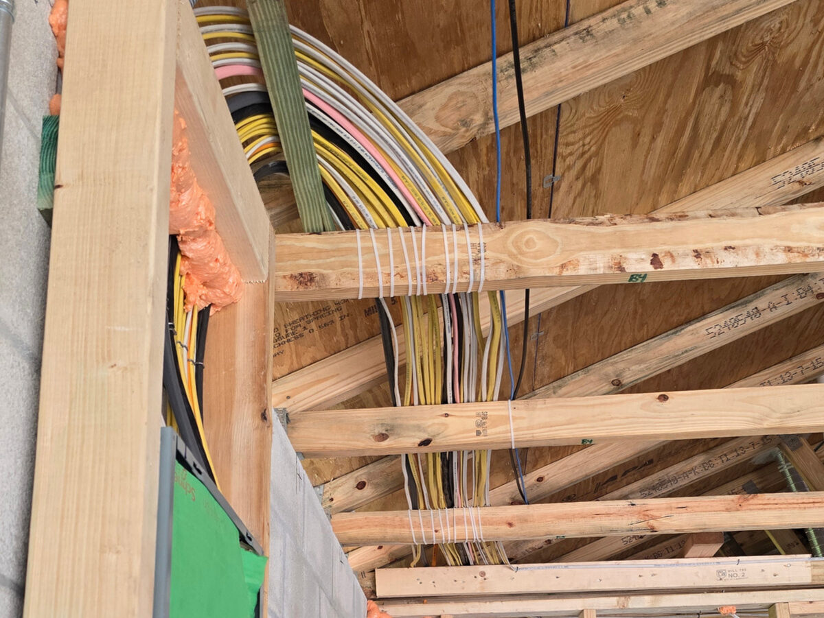 Organized electrical cables bundled and routed through wood trusses
