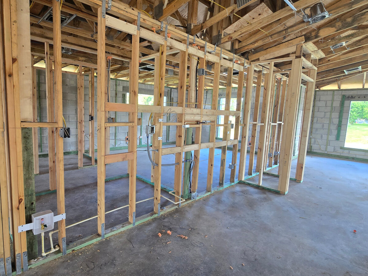 Kitchen area framing with plumbing and electrical rough-in visible