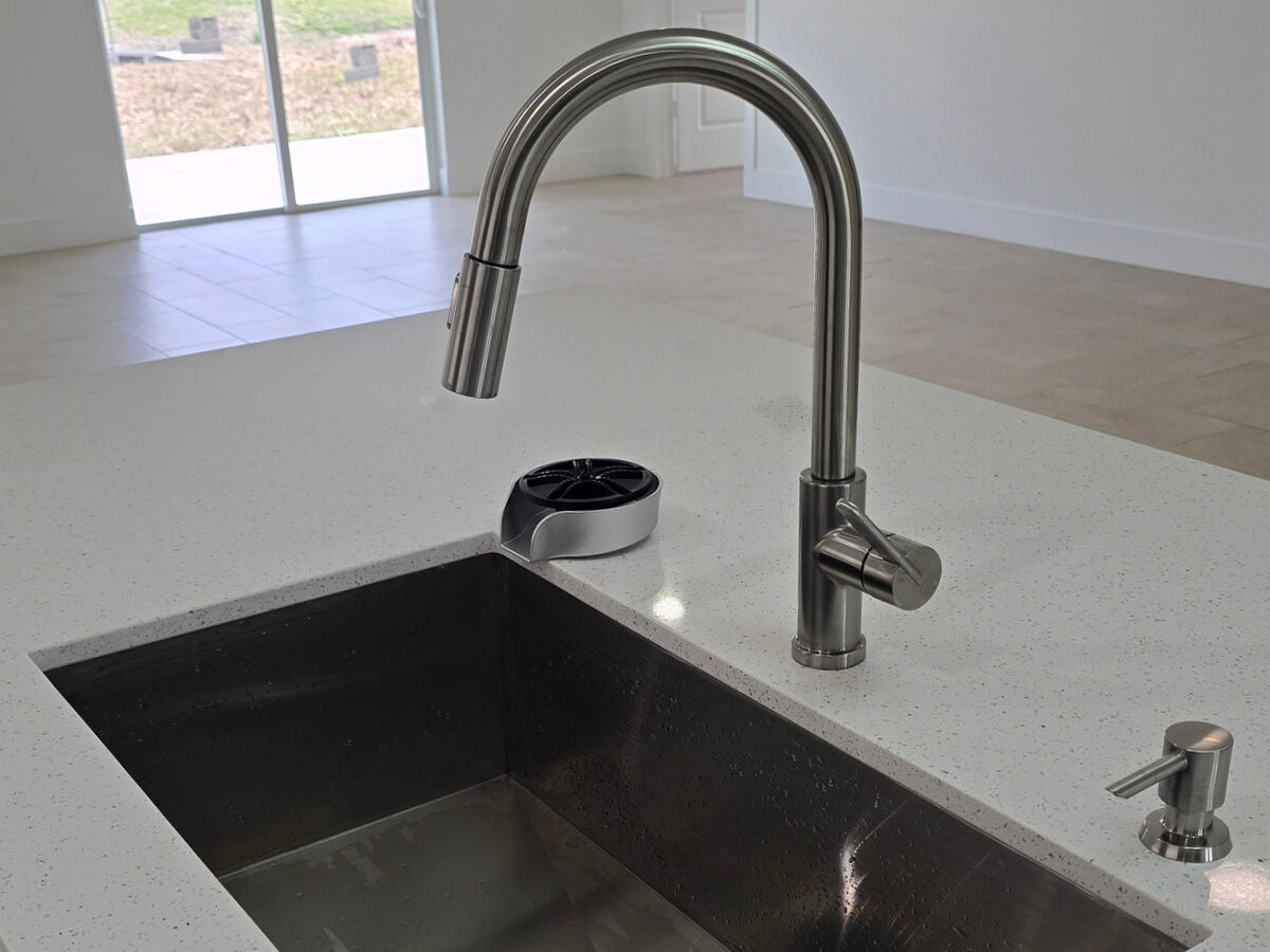 Kitchen sink with glass rinser and soap dispenser on quartz countertop