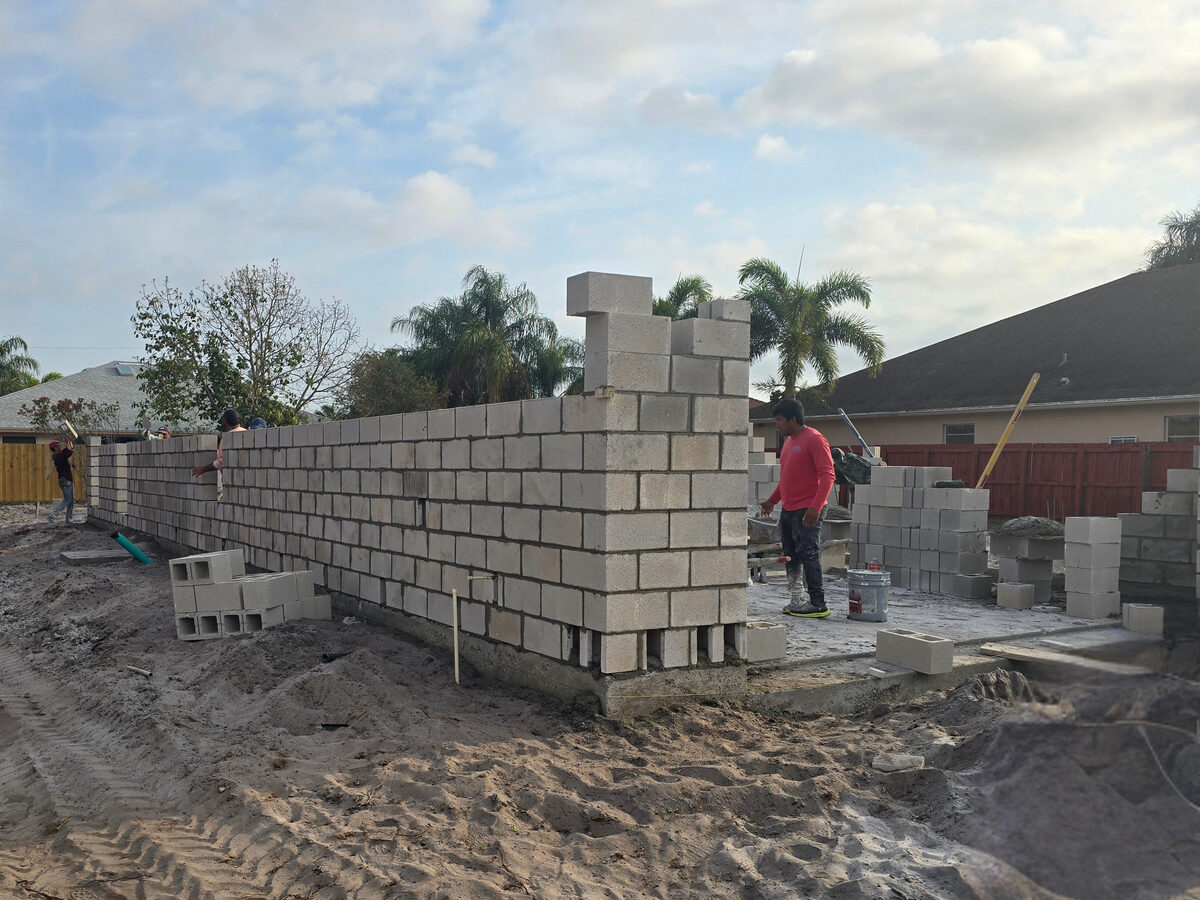 Mason installing CMU block walls on the slab