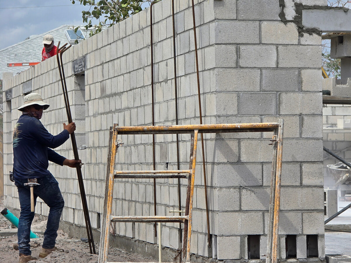 Rebar being placed vertically inside block wall cells