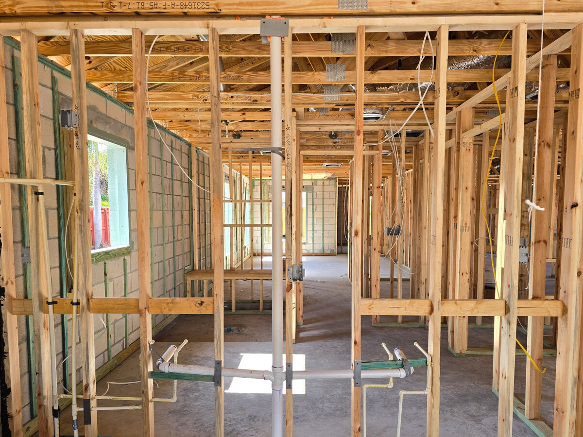 Plumbing rough-in pipes visible through open wall framing