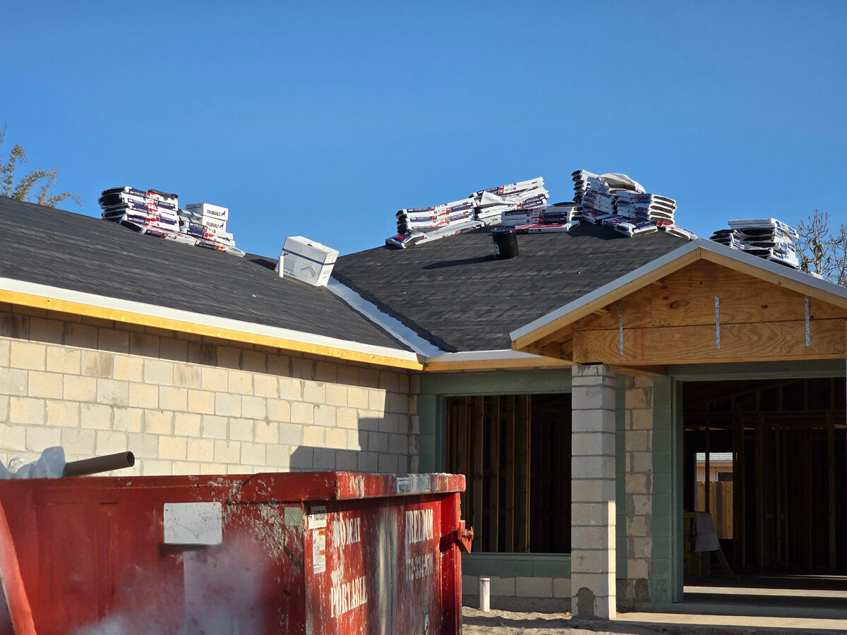 Roof underlayment installed with shingle bundles staged on roof