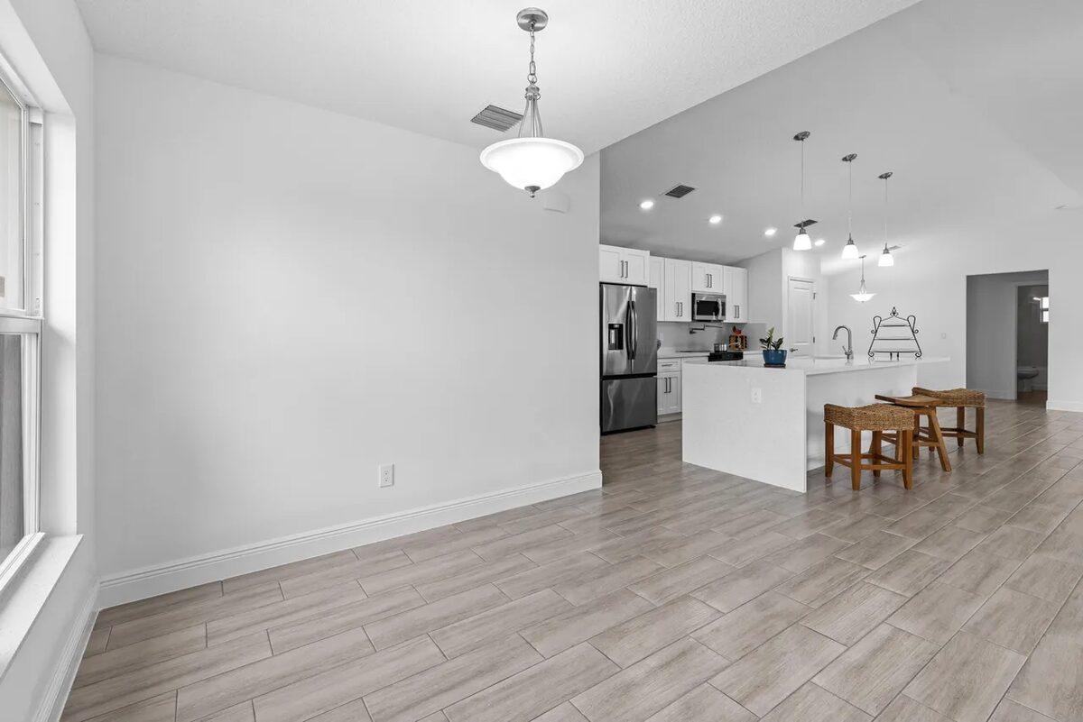 Finished open-concept living area with kitchen island and pendant lighting