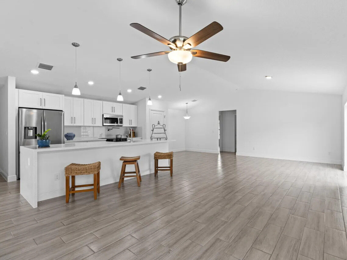 Open-concept living and dining area with wood-look tile floors