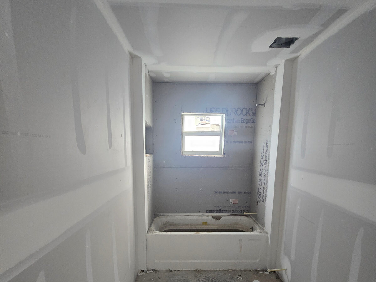 Bathroom drywall and Durock cement board installed around tub area