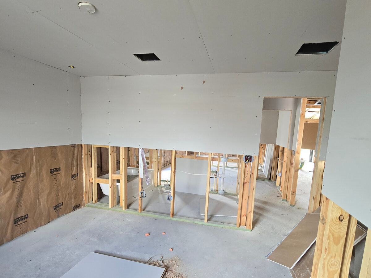 Drywall being hung — ceiling done, Fi-Foil insulation visible on lower walls