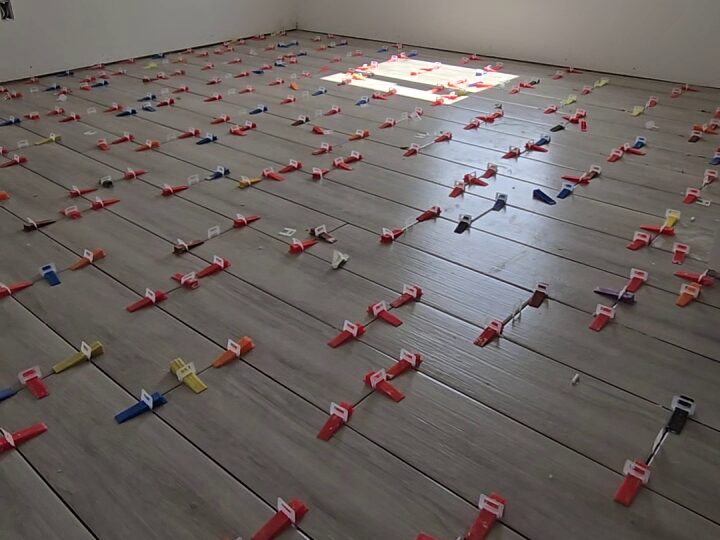 Wood-look tile flooring being installed with leveling clips throughout