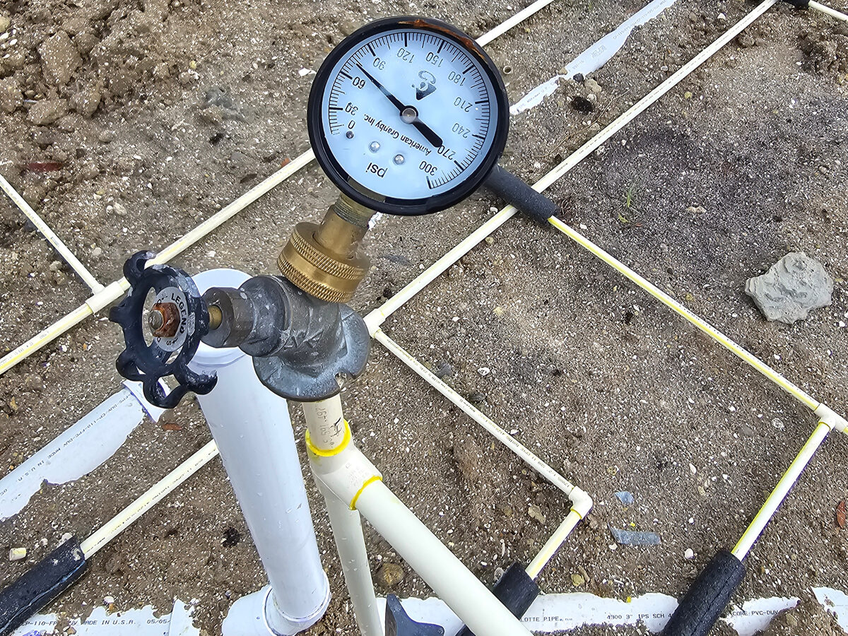 Plumbing pressure gauge showing successful pressure test on underground lines
