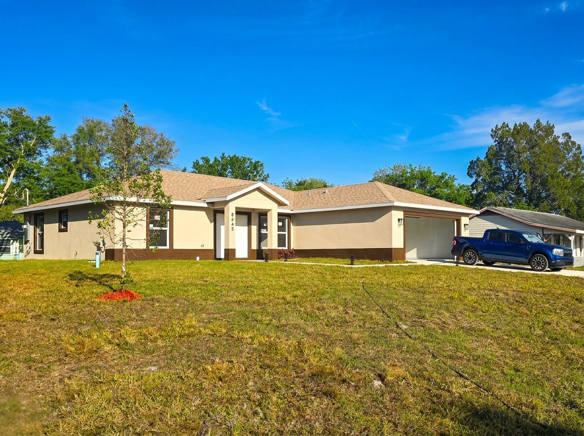 Professional front exterior view of completed home with garage and landscaping