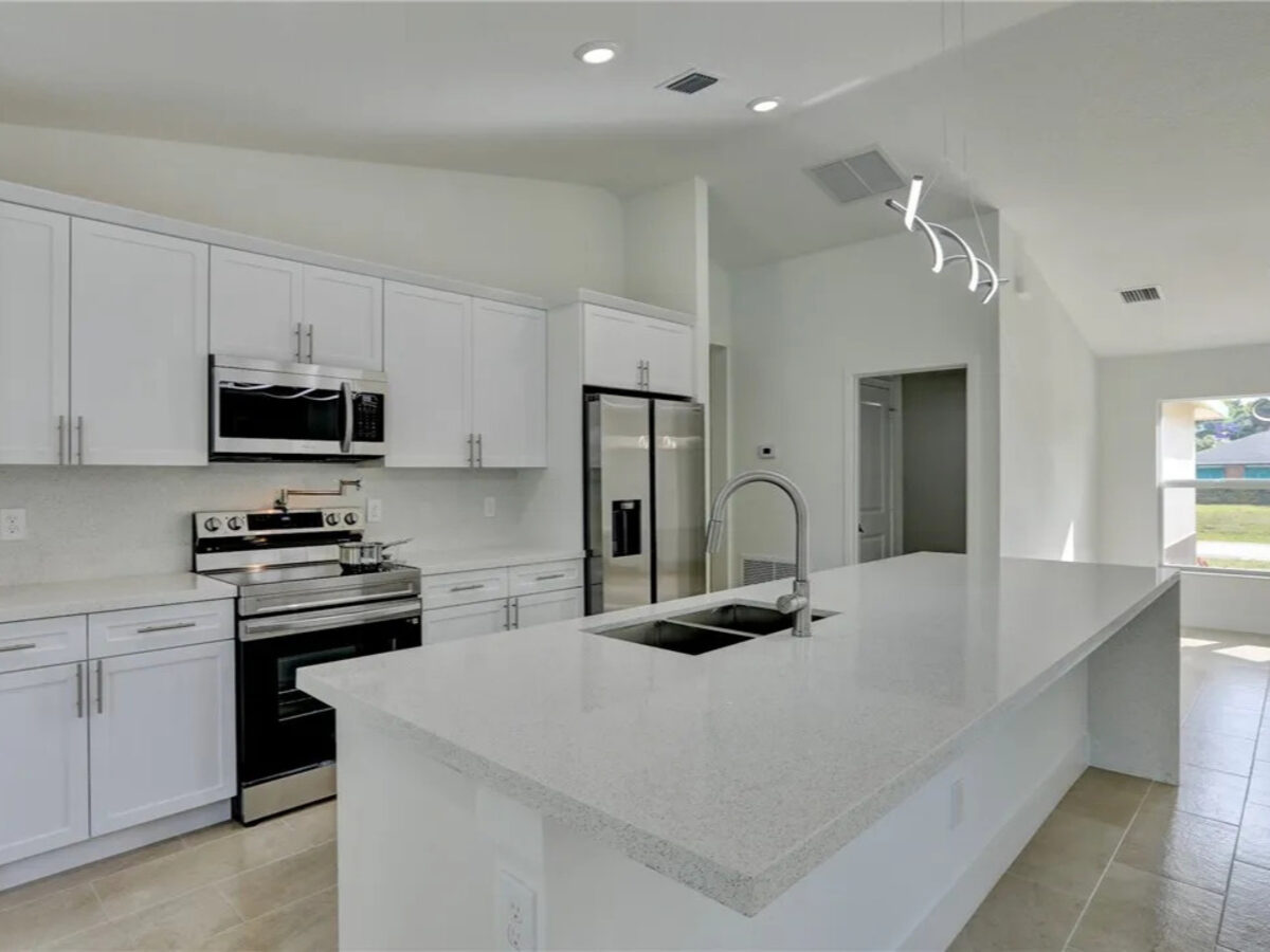 Open-concept living area with kitchen island and modern ceiling fan