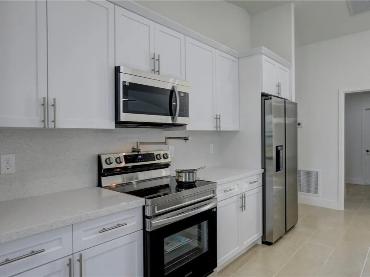 Kitchen close-up with stove, microwave, and stainless refrigerator