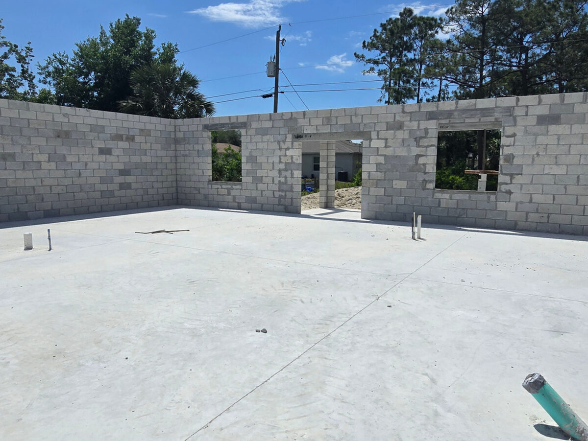 Interior view of slab with CMU block walls and plumbing stubs