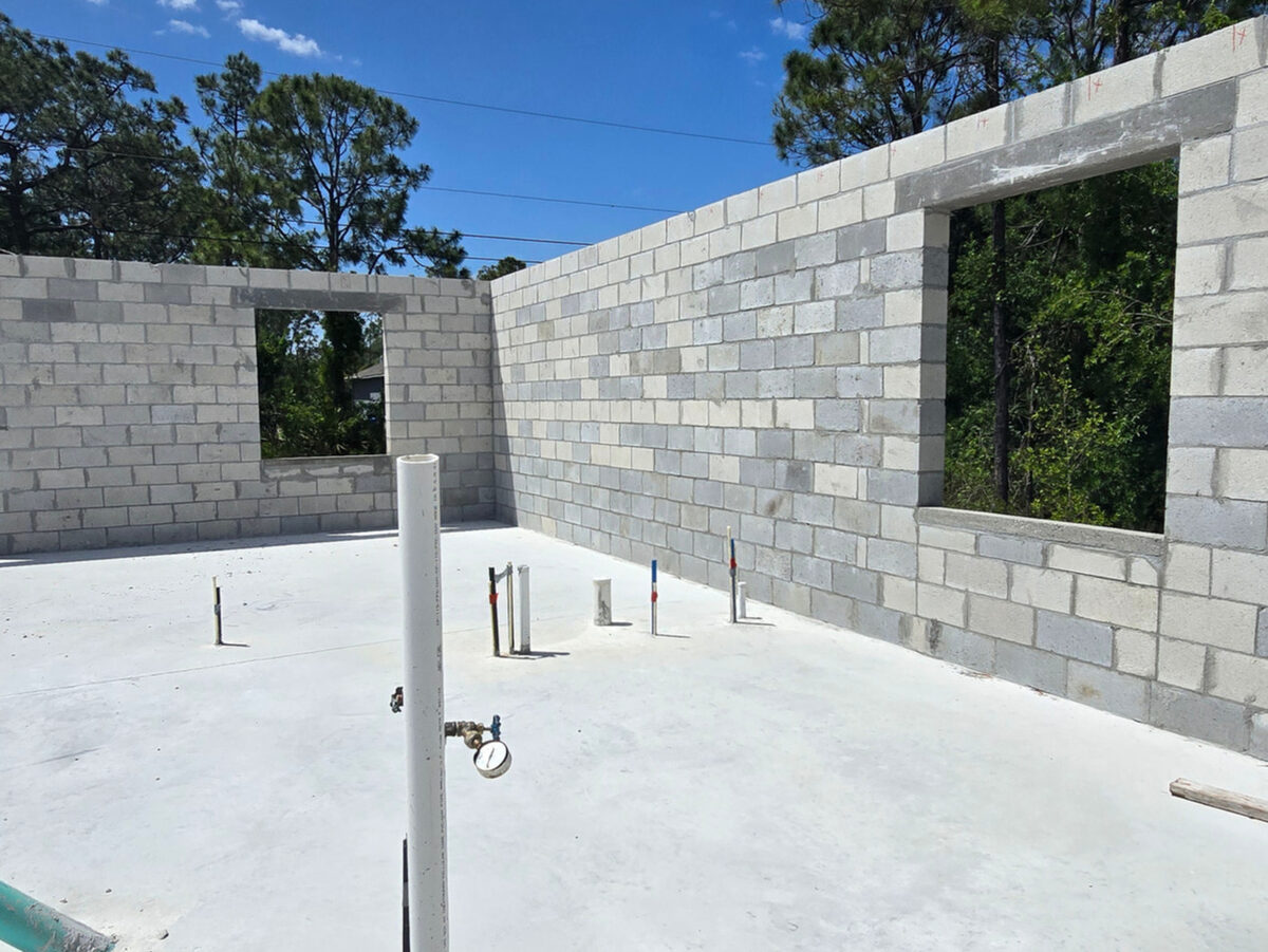 Slab with plumbing risers and block walls with window openings