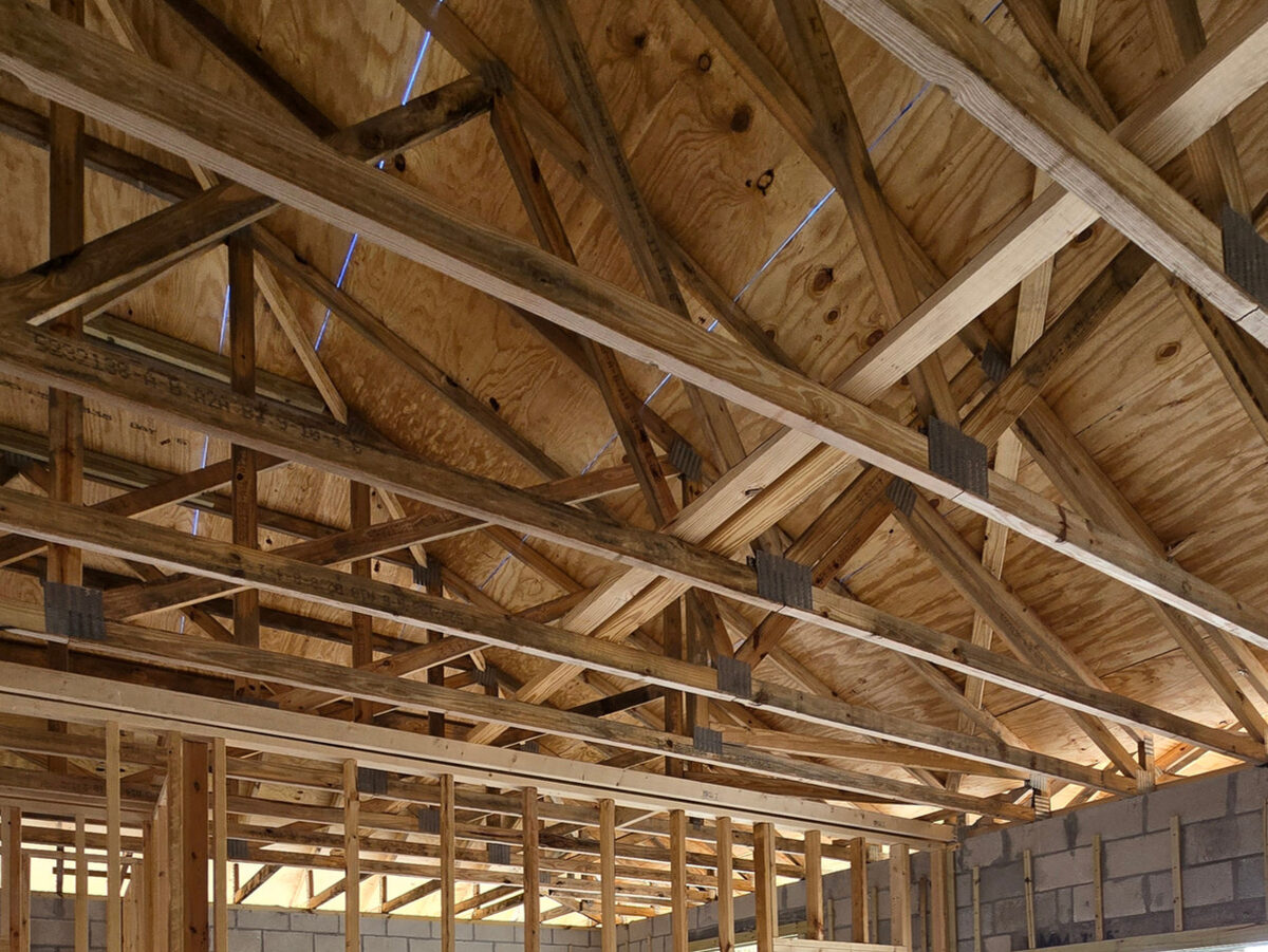 Roof trusses installed with hurricane ties and plywood sheathing