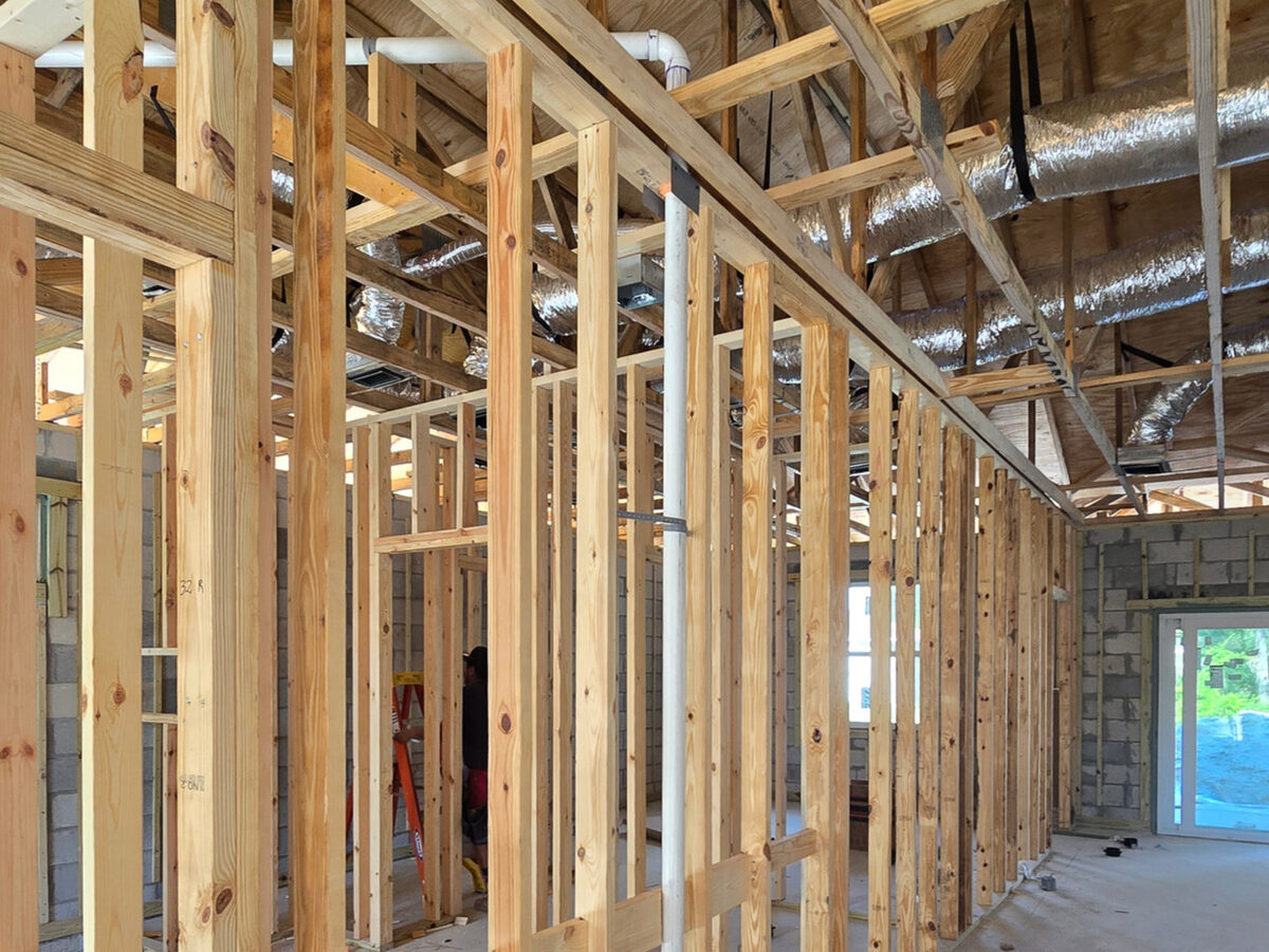 Plumbing pipes and HVAC ducts running through wood framing