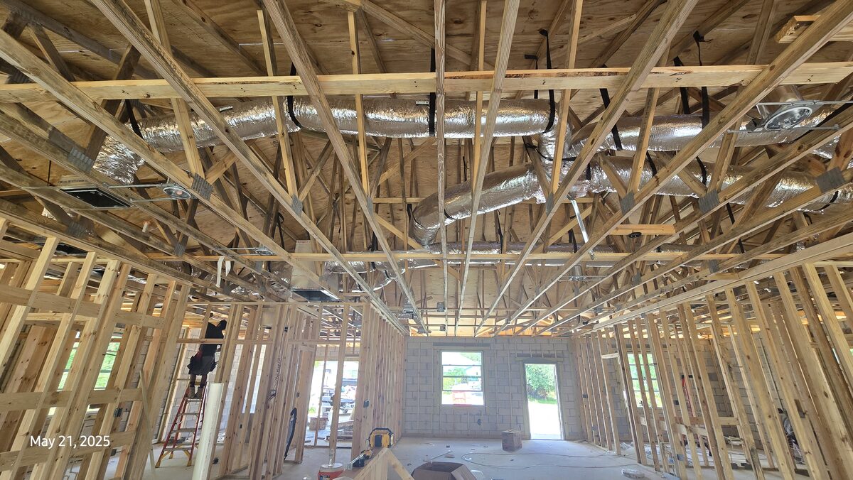 Wide-angle view of HVAC system installed with worker on ladder
