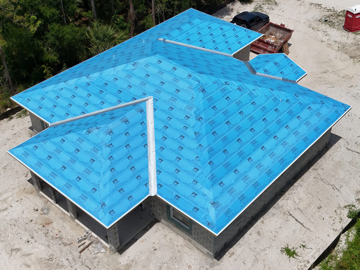 Aerial drone view of full roof underlayment installed over plywood sheathing