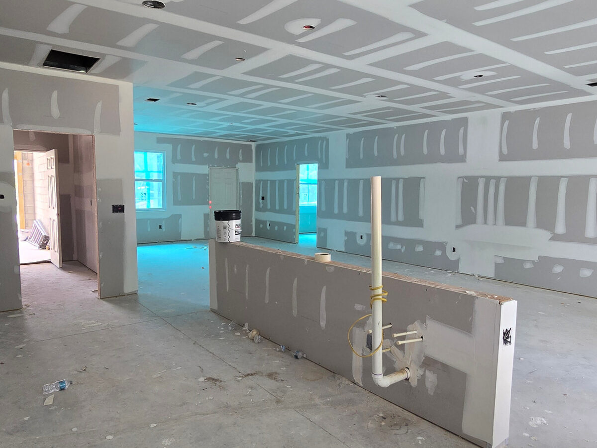 Exterior progress view during drywall phase showing roof and wall completion