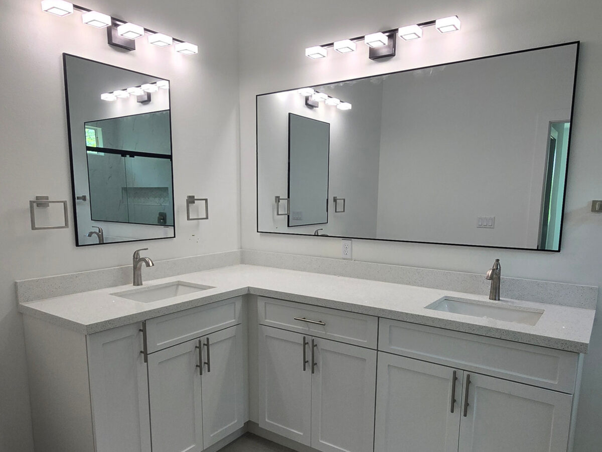 Master bathroom L-shaped double vanity with quartz countertop, framed mirrors and modern vanity lights