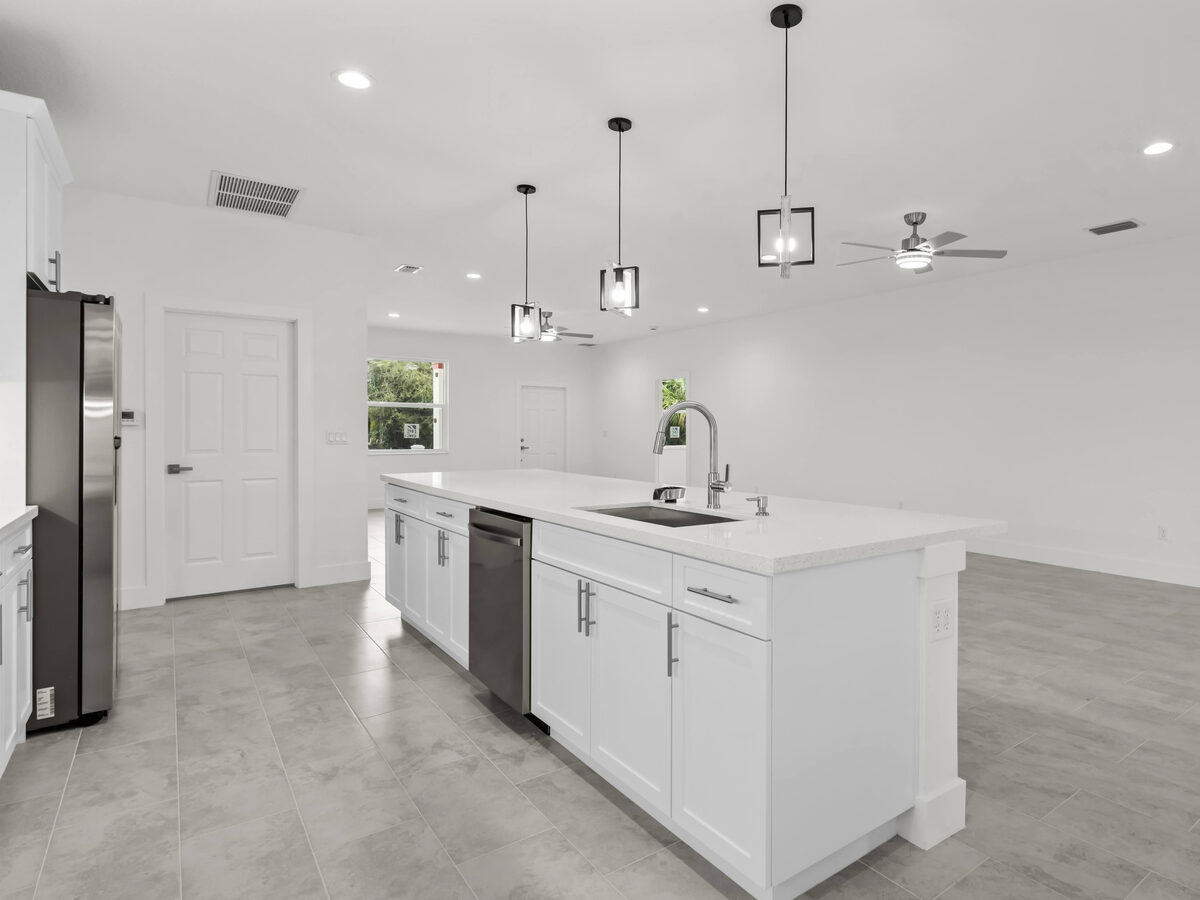 Kitchen island side view with dishwasher, undermount sink and open floor plan to living area