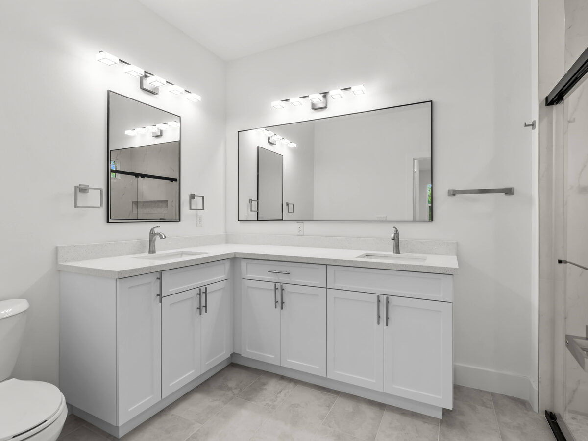 Master bathroom L-shaped double vanity with quartz countertop, framed mirrors and modern vanity lights